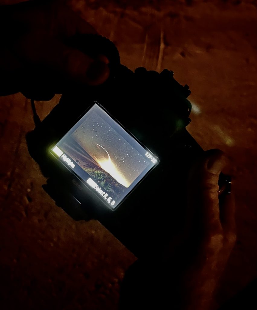 Photographer Bob Gibson checks the back of his Nikon camera to view a Cape Canaveral Rocket Launch
