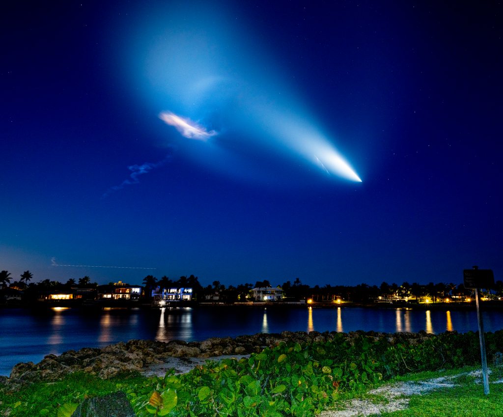 The SpaceX Falcon Rocket creates a halo of light as it rises above the Florida coast at night. 