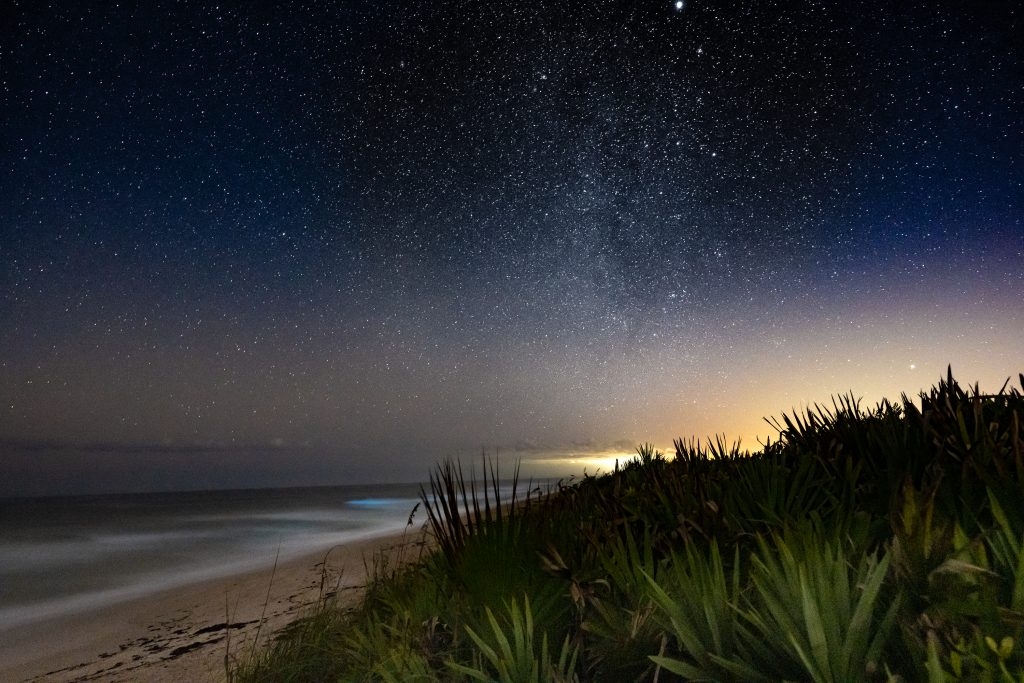 Canaveral National Seashore at Night showing the winter Milky Way and the glow of Kennedy Space Center